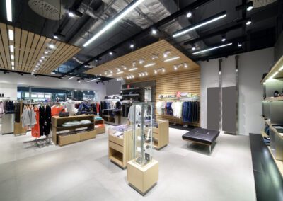 Modern clothing store interior with neatly organized apparel and accessories on display.