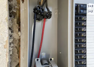 Open electrical panel with visible wiring and circuit breakers.